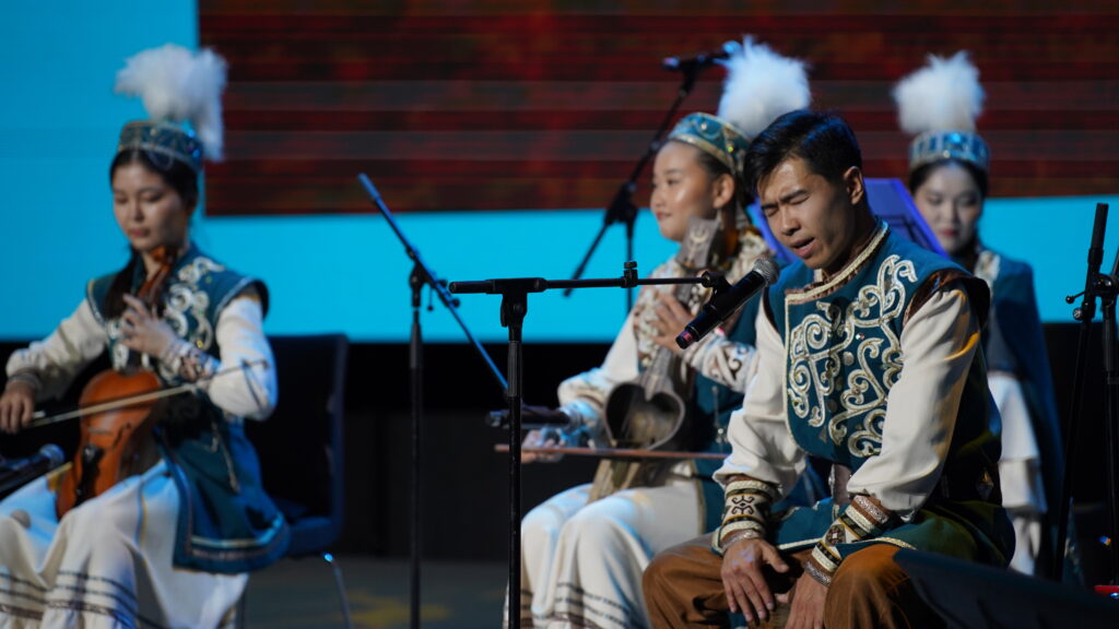 Kazakh music group interpreting songs in traditional clothing.