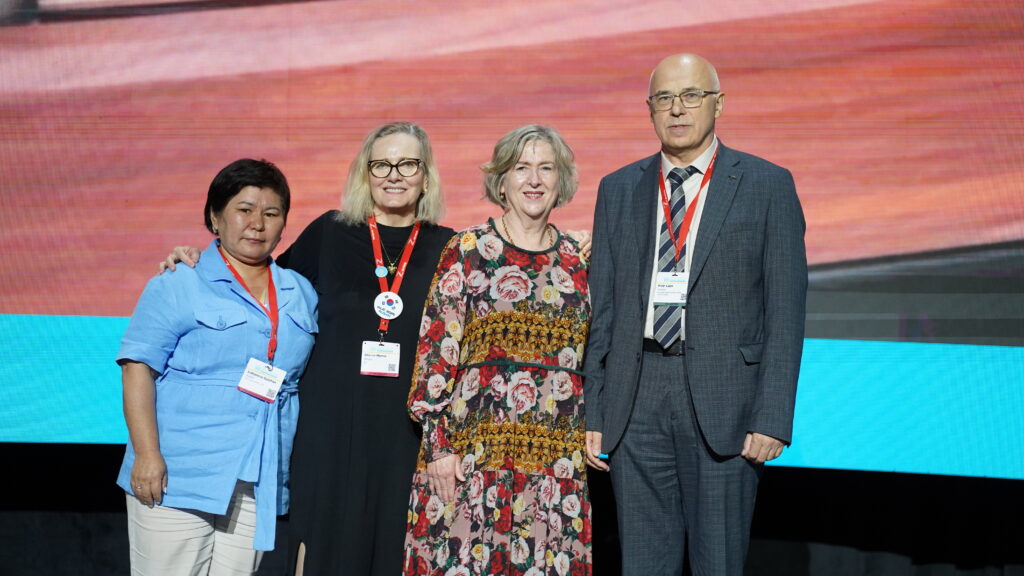 A group of people standing on a stage posing for a picture